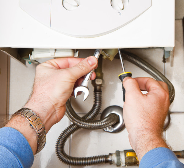 An image of a gas safe registered plumber carrying out a boiler service.